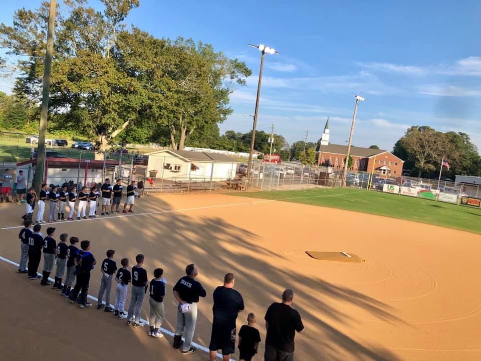 Young baseball players saying the Pledge of Allegiance before the game