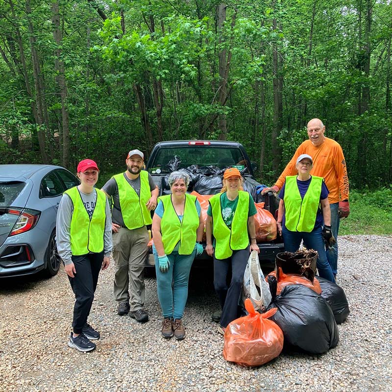 volunteers smiling for a photo with full bags of litter