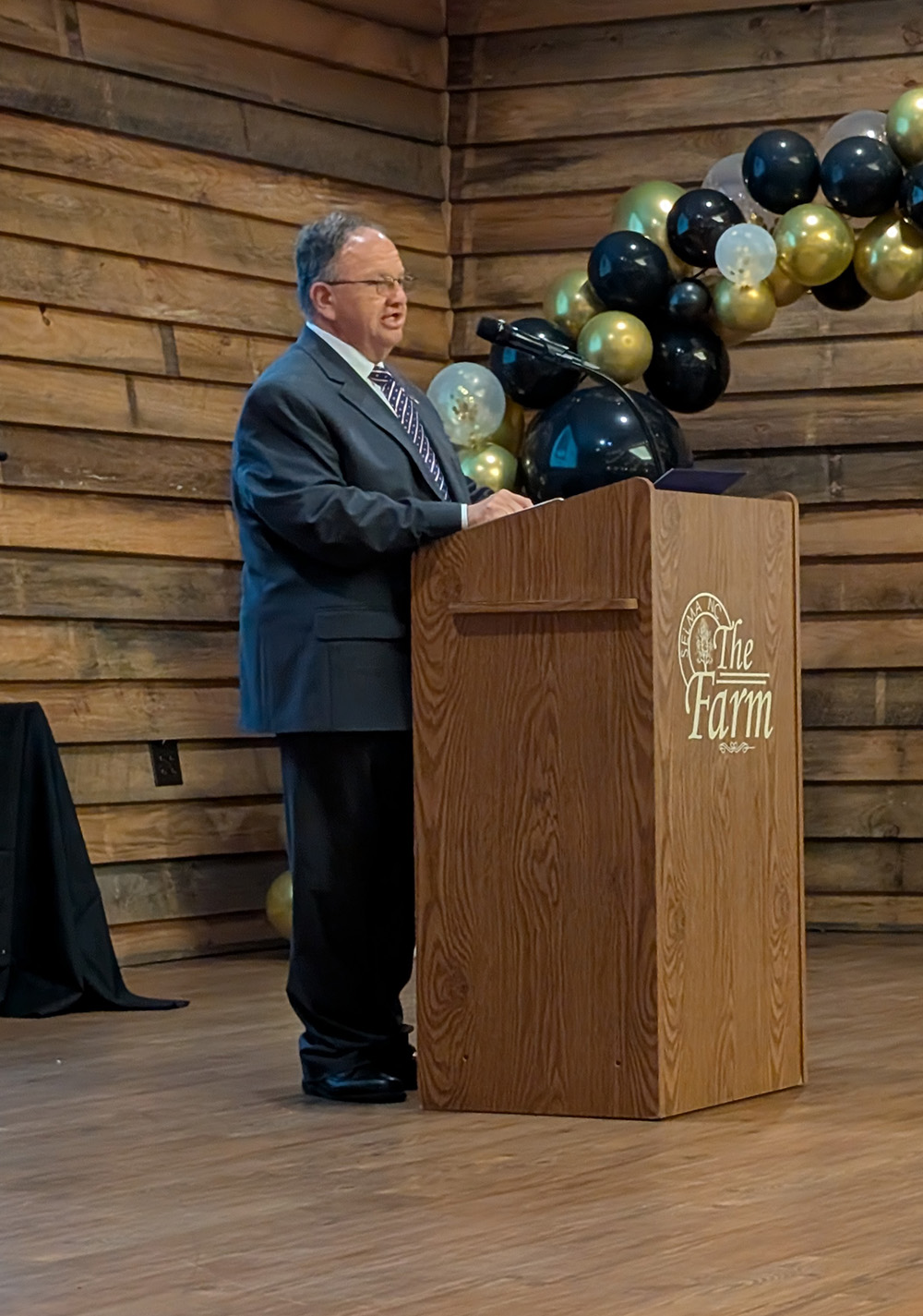 Photo of Craig Olive speaking at a podium.