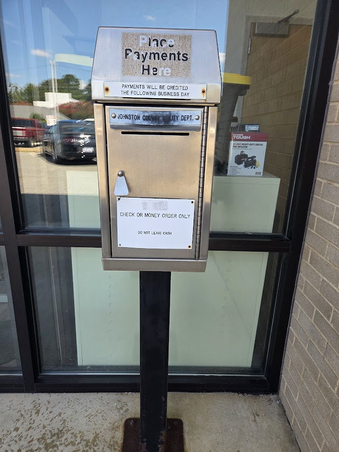 Silver drop box on a post, found in front of the Land Use Center.